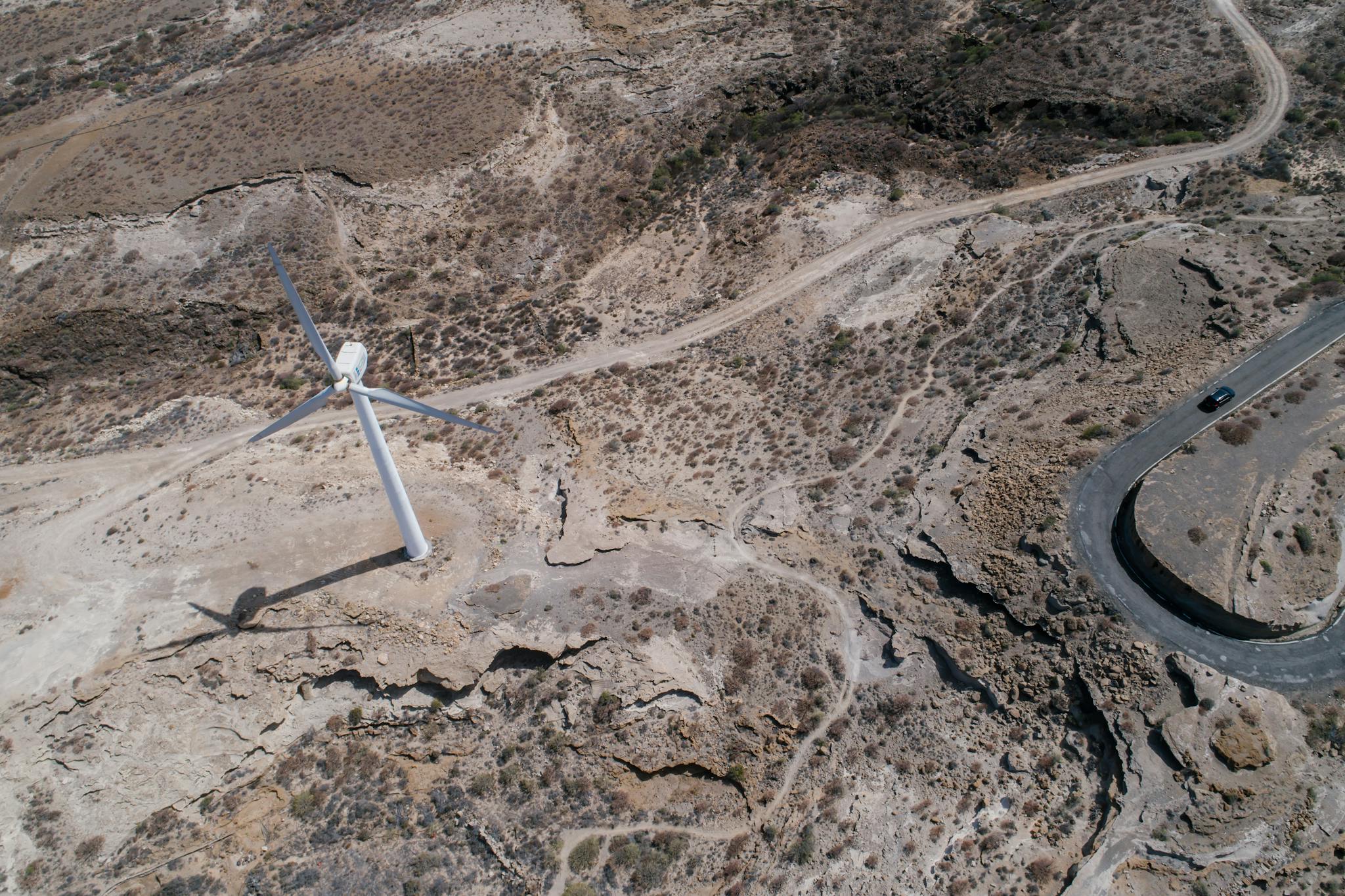 White Wind Turbine Beside a Road